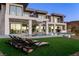 Luxury backyard with pool, waterfall feature, lounge chairs on a grassy lawn and a modern home at 25 Rockstream Dr, Henderson, NV 89012