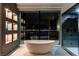 Bathroom with standalone tub and luxurious glass enclosed shower overlooking city lights at night at 25 Rockstream Dr, Henderson, NV 89012