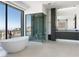 Bathroom featuring a standalone tub, glass shower, and modern vanity with city views at 25 Rockstream Dr, Henderson, NV 89012