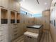 Custom walk-in closet with built-in shelving, drawers, seating and dark countertop island at 25 Rockstream Dr, Henderson, NV 89012