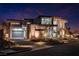 Modern two-story home with clean lines, a three-car garage, and desert landscaping at 25 Rockstream Dr, Henderson, NV 89012