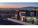 Modern home exterior with sleek design and a backdrop of the vibrant city skyline at dusk at 25 Rockstream Dr, Henderson, NV 89012