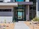 Modern home entrance with glass door, desert landscaping, and a view of the Las Vegas skyline at 25 Rockstream Dr, Henderson, NV 89012