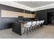 Sleek kitchen featuring black and wood cabinets, an island with seating, and pendant lighting at 25 Rockstream Dr, Henderson, NV 89012