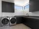 Well-organized laundry room featuring modern appliances, ample counter space, and sleek, dark cabinetry at 25 Rockstream Dr, Henderson, NV 89012
