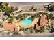 Aerial view of a community pool featuring a freeform design, surrounded by palm trees, landscaping, and lounge areas at 2555 Hampton Rd # 2308, Henderson, NV 89052