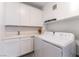 Functional laundry room with white washer, dryer, sink, and ample cabinet storage at 2555 Hampton Rd # 2308, Henderson, NV 89052