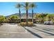 An inviting clubhouse entrance boasts mature palms, manicured landscaping and a circular drive with golf carts nearby at 2571 Red Springs Dr, Las Vegas, NV 89135