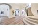 Bright foyer featuring wood floors, staircase, white walls, and arched doorways at 2571 Red Springs Dr, Las Vegas, NV 89135