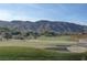 Scenic golf course view showcases rolling hills, a pristine fairway, sand traps, and mature landscaping with mountain backdrop at 2571 Red Springs Dr, Las Vegas, NV 89135