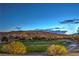 Tranquil golf course view with lush green fairways and the silhouette of majestic mountains against the evening sky at 2571 Red Springs Dr, Las Vegas, NV 89135