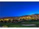 Picturesque view of a well-manicured golf course under a starlit sky, set against a backdrop of illuminated mountains at 2571 Red Springs Dr, Las Vegas, NV 89135