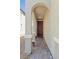 Inviting front entrance with arched doorway and brick pathway leading to a red front door with potted flowers at 2932 Tranquil Brook Ave, Henderson, NV 89044
