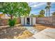 Secluded backyard with stone pathway leading to white shed, offering ample shade at 3016 Light Wind Ct, Las Vegas, NV 89108