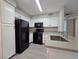 Contemporary kitchen with white cabinetry, black appliances, and ample counter space, blending style and functionality at 3038 Tarpon Dr # 203, Las Vegas, NV 89120