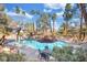 Community pool surrounded by palm trees and seating areas at 3038 Tarpon Dr # 203, Las Vegas, NV 89120