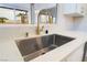 Close up view of the kitchen sink with white quartz countertop and gold faucet at 3157 Faiss Dr, Las Vegas, NV 89134