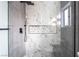 Modern shower with marble-look tile, pebble floor, and sleek fixtures at 3157 Faiss Dr, Las Vegas, NV 89134
