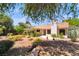 Spacious backyard featuring desert landscaping, mature trees, and a covered patio at 3221 Palmdesert Way, Las Vegas, NV 89120
