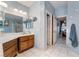 Well-lit bathroom featuring a double sink vanity, white tile floors, and an open doorway leading to the bedroom at 3221 Palmdesert Way, Las Vegas, NV 89120