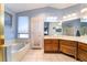 Bright bathroom with a soaking tub, tile floors, and a spacious vanity with ample counter space at 3221 Palmdesert Way, Las Vegas, NV 89120