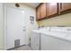 Functional laundry room with white washer and dryer, storage cabinets, and tile flooring at 3221 Palmdesert Way, Las Vegas, NV 89120