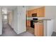 Kitchen area with light cabinets and black appliances, with a view of the hallway and rooms at 3318 N Decatur Blvd # 2073, Las Vegas, NV 89130