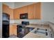 Kitchen area with light countertops, light wood cabinets and black appliances including a gas stove at 3318 N Decatur Blvd # 2073, Las Vegas, NV 89130