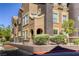 Multi-story building with secure front fence. The architecture features dual-toned stucco and mature landscaping at 3975 N Hualapai Way # 147, Las Vegas, NV 89129