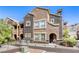 Multi-story building showing architecture details, with dual-toned stucco and mature landscaping with a secure front fence at 3975 N Hualapai Way # 147, Las Vegas, NV 89129