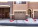 Exterior view of a multi-car garage with brown doors and light stone trim at 3975 N Hualapai Way # 147, Las Vegas, NV 89129