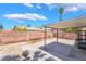 An inviting backyard patio featuring a metal shade cover and a sturdy brick wall, offering a private outdoor retreat at 4498 Via San Rafael, Las Vegas, NV 89103