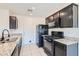 Galley kitchen featuring black appliances, granite countertops, and white tile flooring at 4539 Cotton Quail Ave, Las Vegas, NV 89115