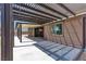 Covered backyard patio has concrete floor, with decorative brick, next to the home at 4818 Al Carrison St, Las Vegas, NV 89149