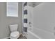Bright bathroom featuring a white tub, striped shower curtain and tiled walls at 4818 Al Carrison St, Las Vegas, NV 89149