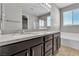 Bathroom with a double sink vanity with dark cabinets and a large mirror at 4818 Al Carrison St, Las Vegas, NV 89149
