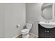 Half bathroom featuring vanity with cabinet and toilet, complemented by a modern mirror at 4818 Al Carrison St, Las Vegas, NV 89149