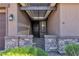 Charming front entrance with a covered porch, stone accents, tasteful plants, and iron gate at 4818 Al Carrison St, Las Vegas, NV 89149