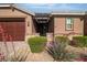 Inviting front of house with well-kept landscaping, stone accents, a covered porch and a three car garage at 4818 Al Carrison St, Las Vegas, NV 89149