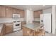 Cozy kitchen features wooden cabinets, white appliances, and a center island with seating at 519 Brinkburn Point Ave, Las Vegas, NV 89178