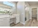 Bathroom featuring double sinks, quartz counters, wood-look floors, and a walk-in shower with marble tile at 5251 Graystone, Pahrump, NV 89061