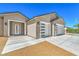 Close up shot of a house featuring a three-car garage, decorative front door and desert landscaping at 5251 Graystone, Pahrump, NV 89061