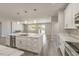 Open kitchen with a marble countertop island with a stainless steel sink and faucet, with bright lighting at 5251 Graystone, Pahrump, NV 89061