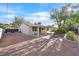 An outdoor oasis featuring a stone fire pit and covered patio with mature shade trees at 5772 Arbor Oak Cir, Las Vegas, NV 89142