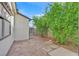 Backyard with a stone pathway leading to a gated fence and lush greenery on the side of the house at 5772 Arbor Oak Cir, Las Vegas, NV 89142