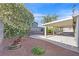 Cozy backyard with a covered patio, garden beds, and a mature tree in bloom at 5772 Arbor Oak Cir, Las Vegas, NV 89142