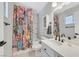 Well-lit bathroom featuring a colorful shower curtain, single sink vanity, and ceramic tiled floor at 5772 Arbor Oak Cir, Las Vegas, NV 89142