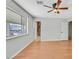 Bright bedroom featuring hardwood floors, large window, ceiling fan and modern decor at 5772 Arbor Oak Cir, Las Vegas, NV 89142