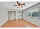 Spacious bedroom with hardwood floors, a large window, and custom built-in closet organizers at 5772 Arbor Oak Cir, Las Vegas, NV 89142
