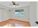 Comfortable bedroom with hardwood floors, a ceiling fan, and a window overlooking the backyard at 5772 Arbor Oak Cir, Las Vegas, NV 89142